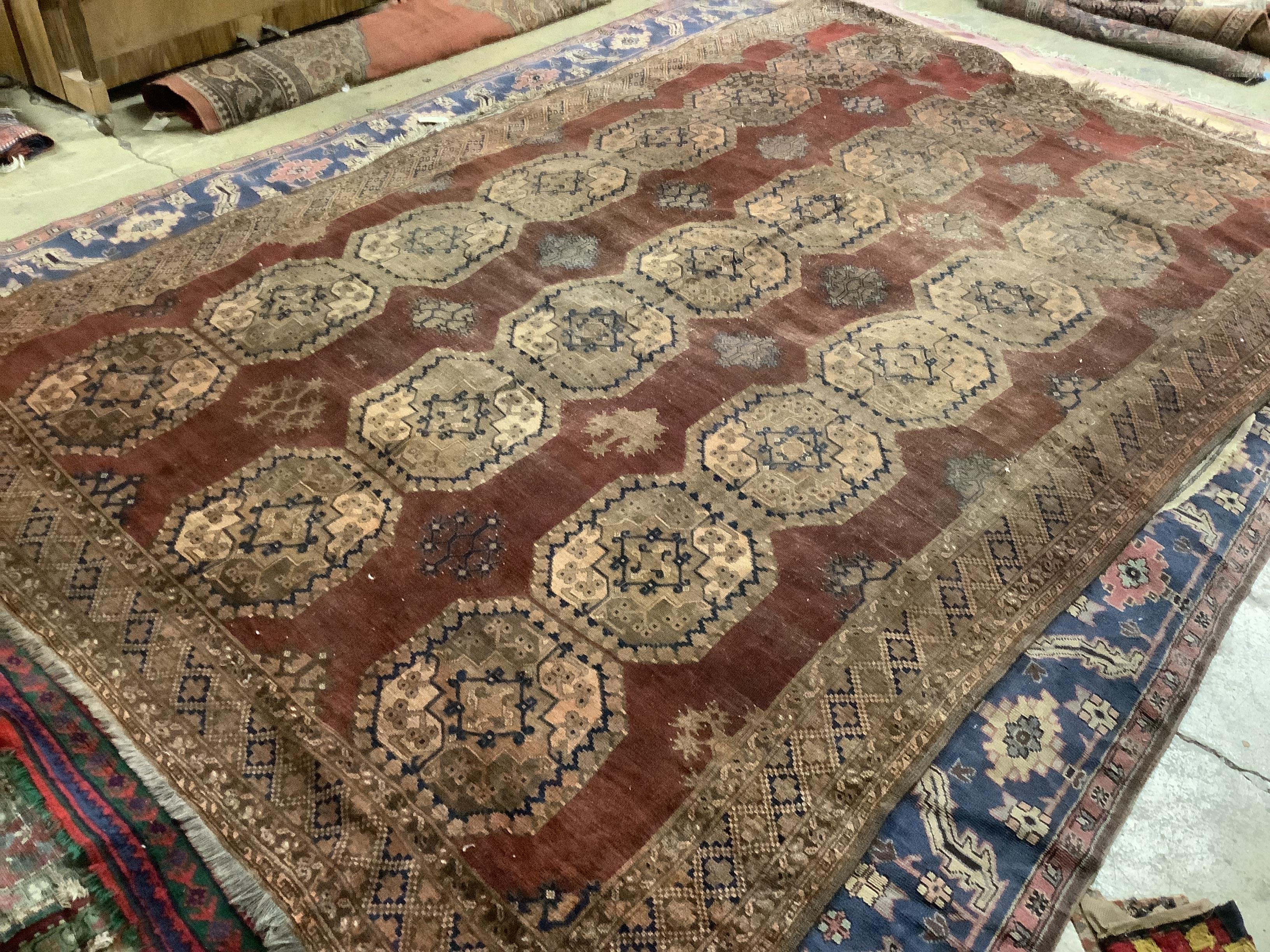 An Afghan brick red ground carpet, 379 x 240cm